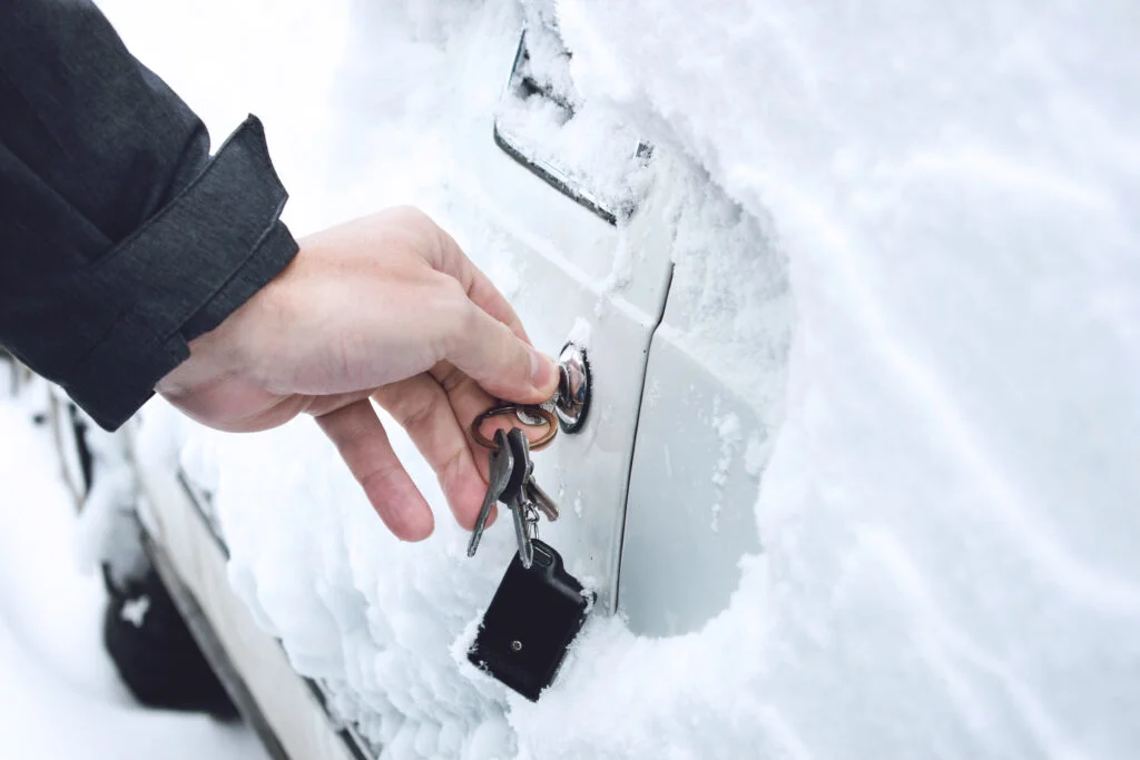 Ways to Open Frozen Car Doors. heating up the key. Male hand opening winter car door with keys
